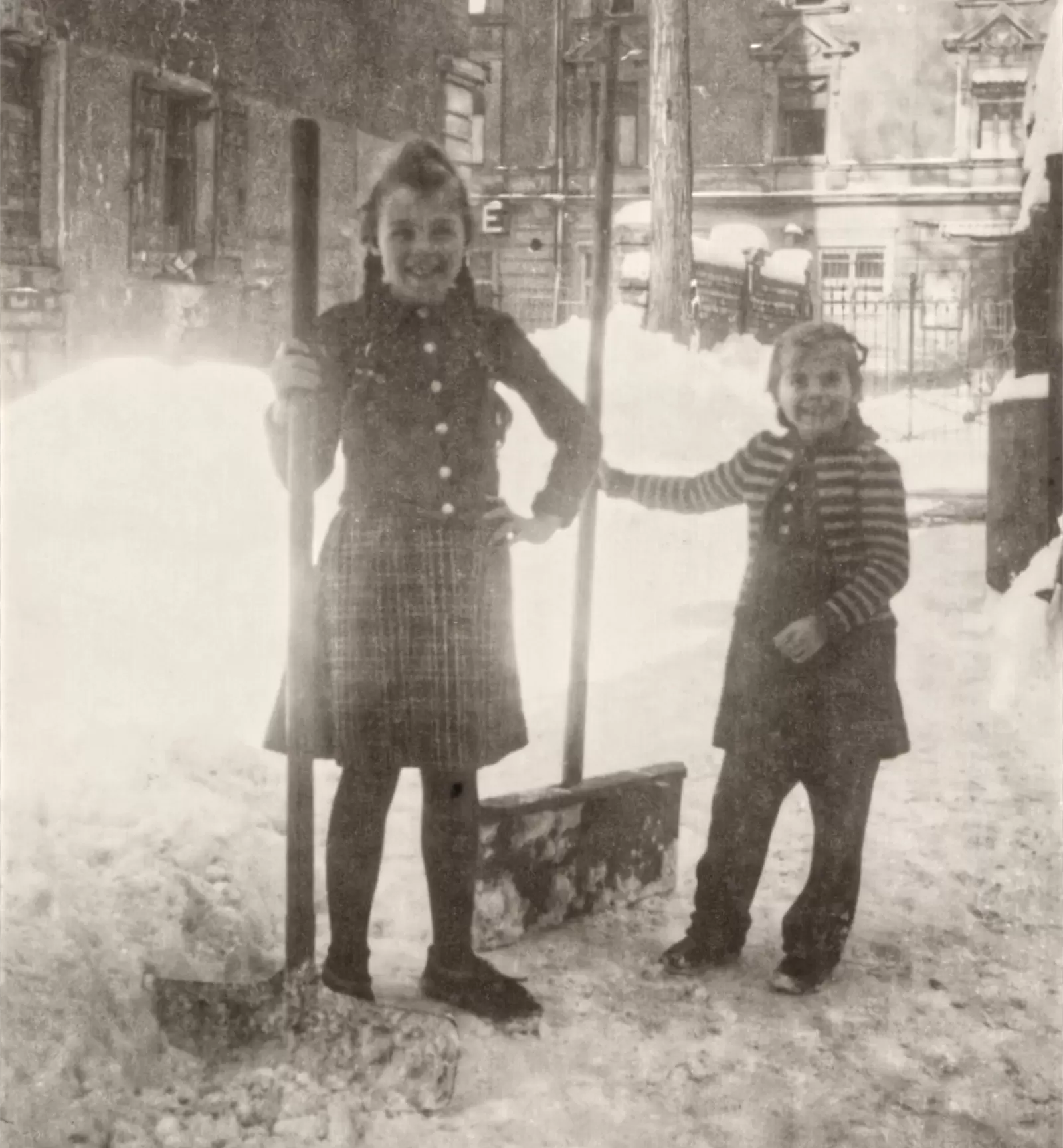 Kinder schieben Schnee zwischen den Ruinen des Krieges